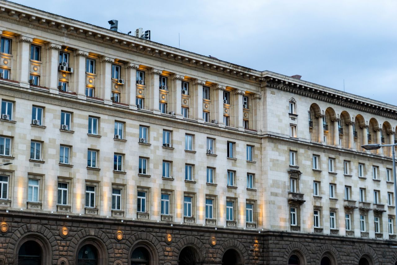 Illuminated government building in Sofia, showing classic architectural design under a twilight sky.